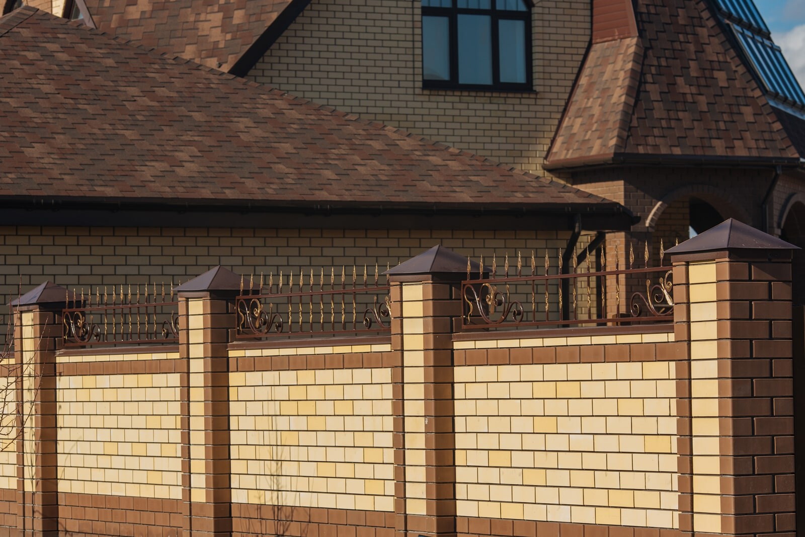 Кирпичный забор с кольями