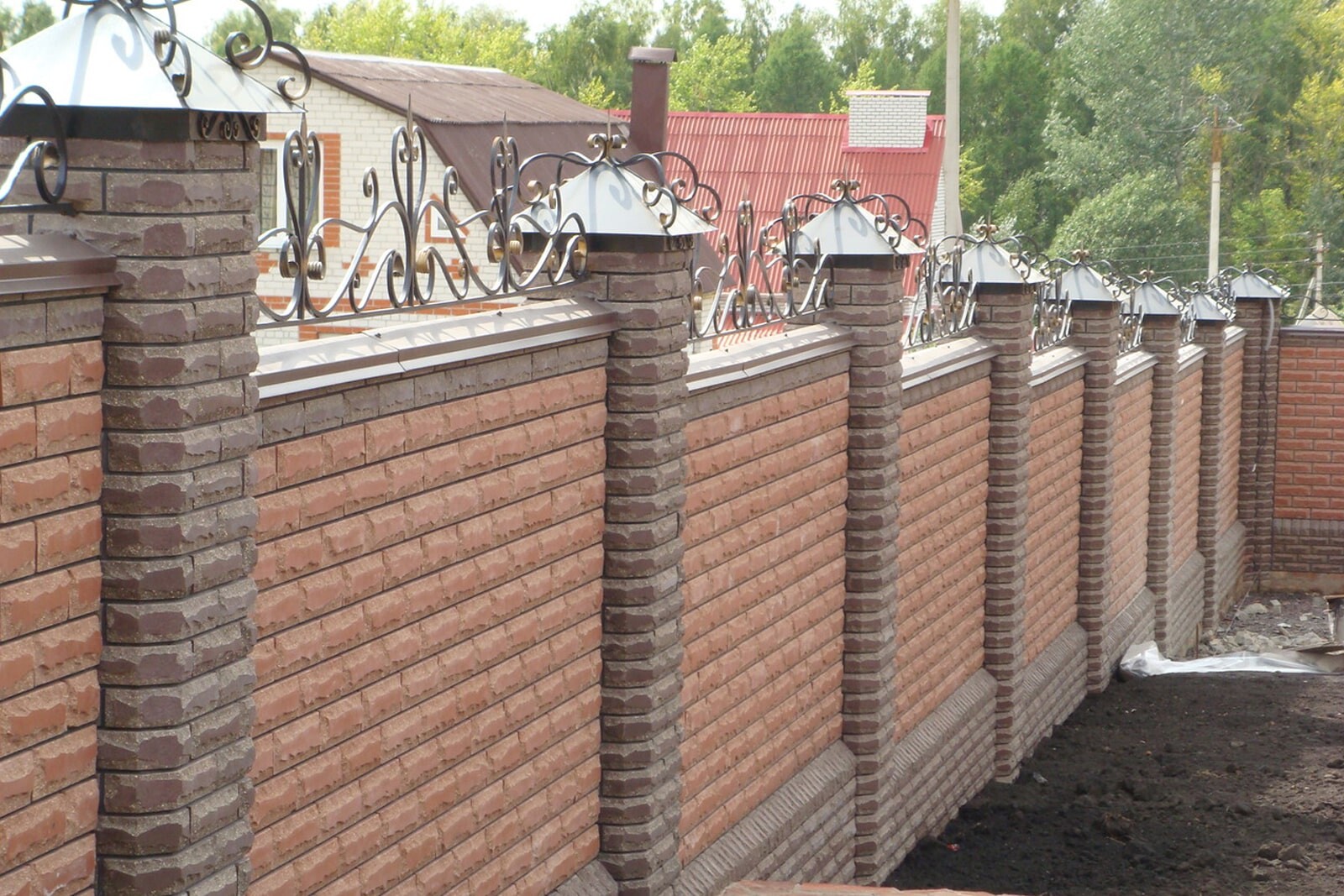 Кирпичный забор на склоне декорированный клинкером